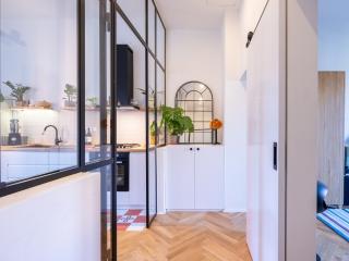 vetrata che separa cucina e soggiorno con profili minimal in acciaio verniciato e vetro trasparente