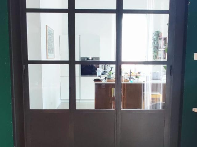 Vetrata con profili in ferro che divide soggiorno da cucina