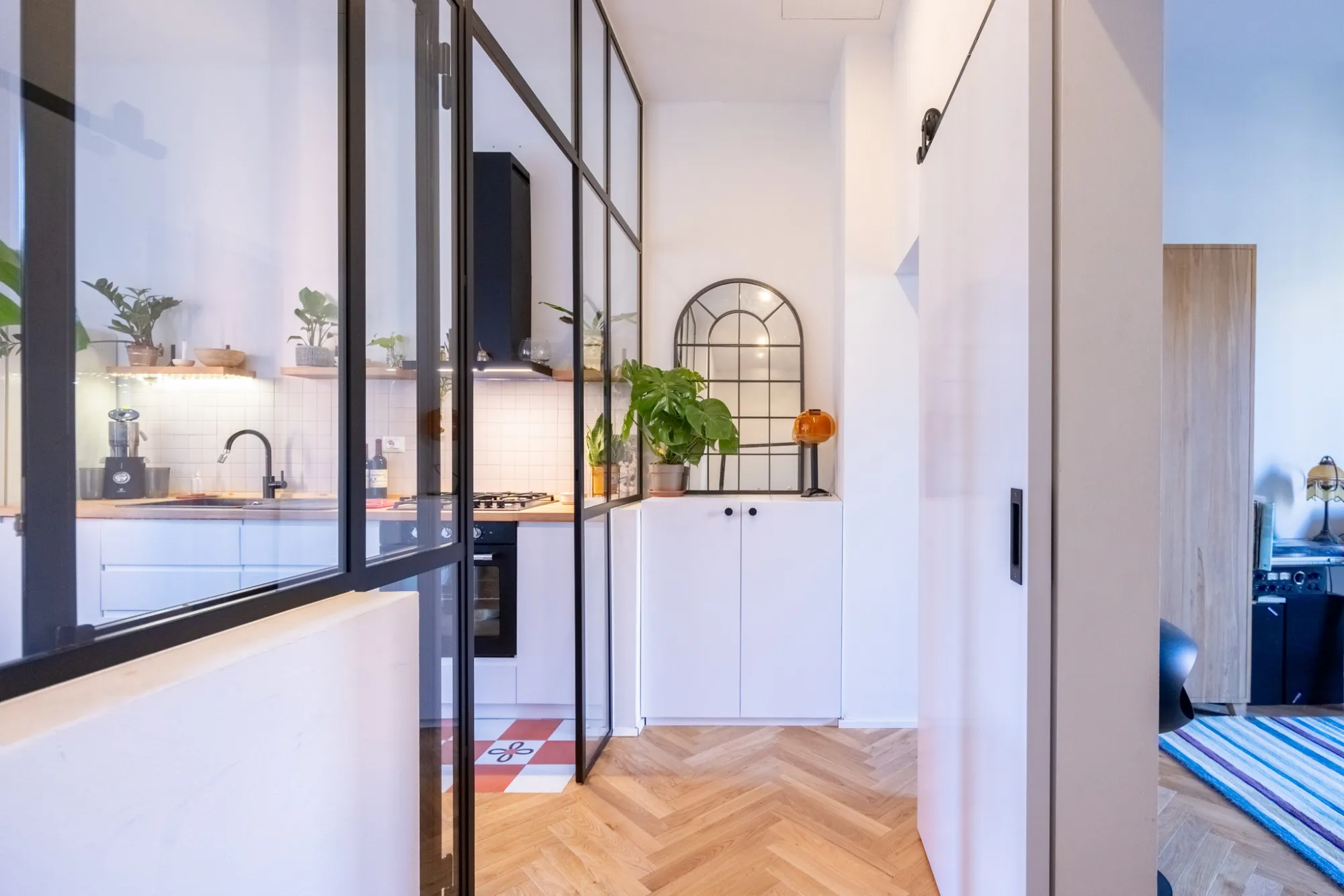 vetrata che separa cucina e soggiorno con profili minimal in acciaio verniciato e vetro trasparente