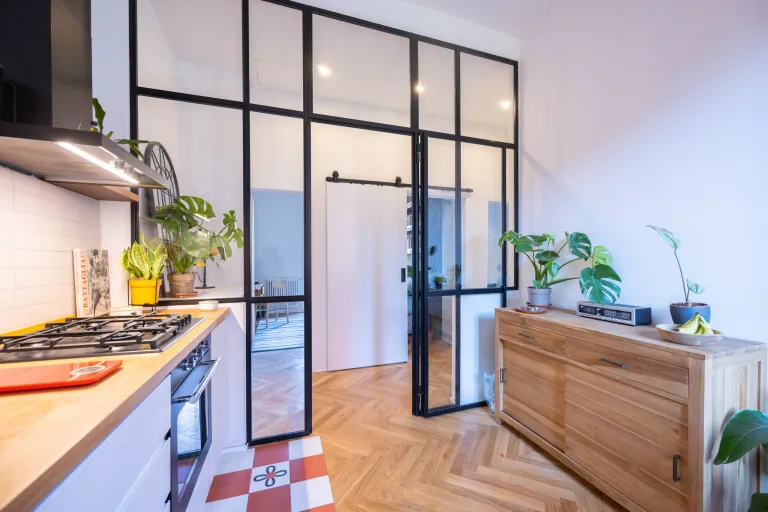 vetrata che separa cucina e soggiorno con profili minimal in acciaio verniciato e vetro trasparente