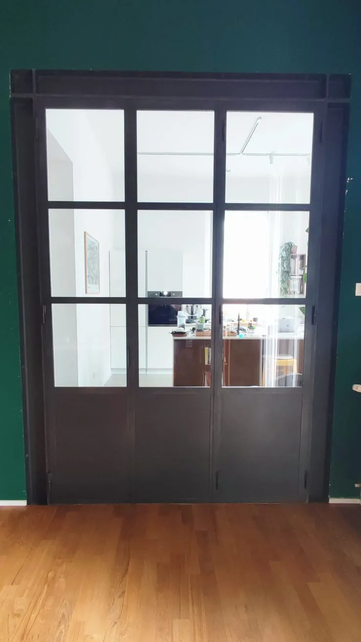 Vetrata con profili in ferro che divide soggiorno da cucina