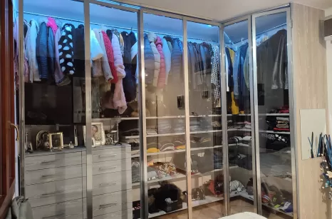 Cabina armadio a vista con profili in acciaio cromato e mensole e cassetti in laminato grigio