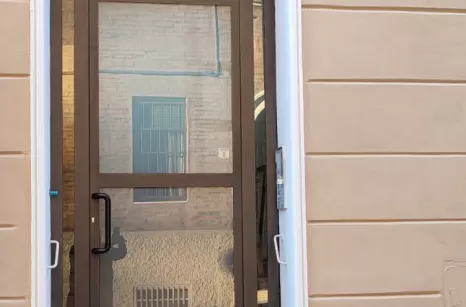 Porta da ingresso condominio con profili in acciaio zincato e verniciato Forster e vetri a specchio