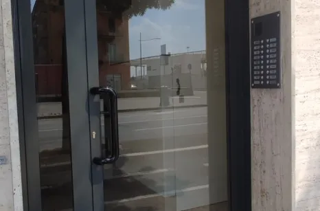 Porta per condominio con profili Foster in acciaio zincato e verniciato e vetro