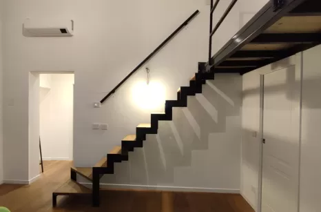 Scala con profili autoportanti in taglio laser stile industrial con gradini in rovere