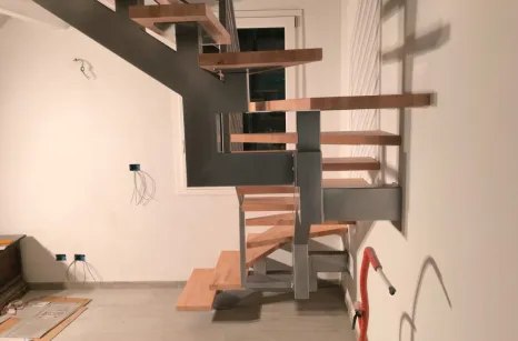 Scala con montante centrale autoportante in acciaio verniciato con gradini in faggio lamellare