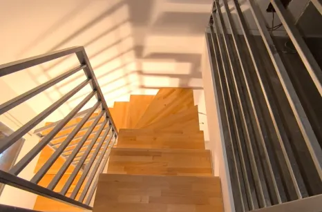 Scala con montante centrale autoportante in acciaio verniciato con gradini in faggio lamellare