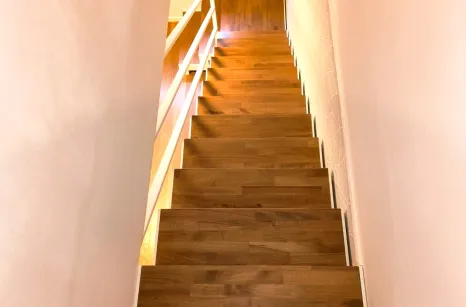 Scala con struttura in taglio laser portante in acciaio verniciato con gradini in faggio lamellare con tinta simile al parquet