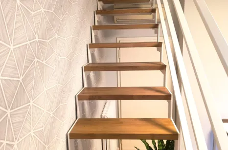 Scala con struttura in taglio laser portante in acciaio verniciato con gradini in faggio lamellare con tinta simile al parquet