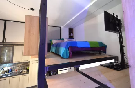 Camera realizzata con soppalco e scala in ferro grezzo