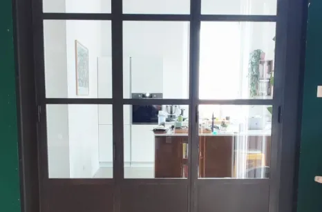 Vetrata con profili in ferro che divide soggiorno da cucina